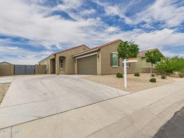 Charming single story home boasts a desert landscape, neutral paint, and an attached two car garage at 235 S San Gregorio Ln, Casa Grande, AZ 85194