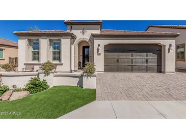 Charming home featuring a brown garage door, landscaped front yard, and inviting entryway with decorative details at 36053 N Stoneware Dr, Queen Creek, AZ 85140