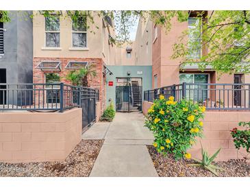 Charming exterior showcasing a walkway adorned with lush greenery and flowering plants at 706 E Washington St # 204, Phoenix, AZ 85034