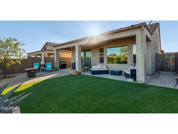 Beautiful backyard featuring an artificial lawn, covered patio, and comfortable outdoor seating at 8205 S Pioneer Ct, Gold Canyon, AZ 85118