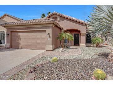 Charming single-story home with desert landscaping, arched entry, and a two-car garage at 9706 E Sheena Dr, Scottsdale, AZ 85260