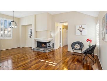 Bright living room featuring a cozy fireplace and hardwood floors at 10015 E Mountain View Rd # 2010, Scottsdale, AZ 85258
