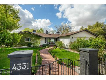 Charming home with a brick walkway, green lawn, and mature landscaping at 4331 E Avalon Dr, Phoenix, AZ 85018