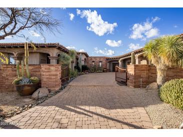 Impressive gated driveway with paver stones leading to an estate home surrounded by desert landscaping at 9920 E Honey Mesquite Dr # 155, Scottsdale, AZ 85262