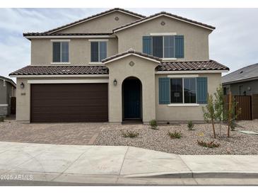 Charming two-story home featuring a two-car garage, desert landscaping, and decorative shutters at 21608 N Belt Dr, Maricopa, AZ 85138