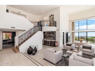 Bright living room with soaring ceilings, a staircase, and a convenient wet bar at 24350 N Whispering Ridge Way # 22, Scottsdale, AZ 85255