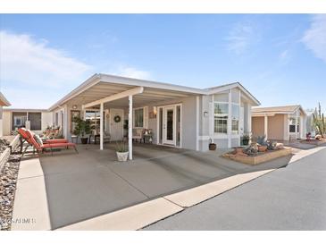 Inviting exterior with a covered carport, charming landscaping and seating area with chairs and views of the community at 5735 E Mcdowell Rd, Mesa, AZ 85215