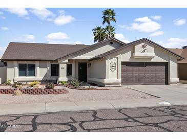 Charming single-story home featuring a two-car garage, desert landscaping, and a welcoming entrance at 8354 W Surrey Ave, Peoria, AZ 85381