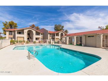 Sparkling community pool with lounge area surrounded by well-maintained landscaping at 10610 S 48Th St # 1068, Phoenix, AZ 85044