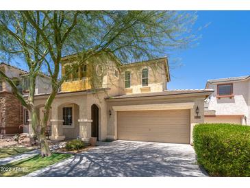 Two-story home features a stucco facade, two-car garage and covered porch with an arched entryway at 12030 W Polk St, Avondale, AZ 85323