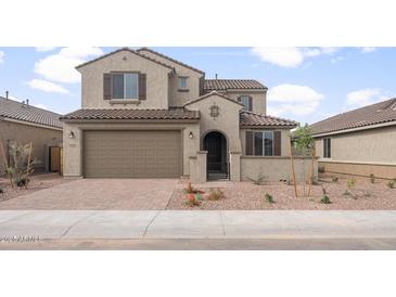 Inviting two-story home showcases a brick-paved driveway, a tiled roof, and a charming gated front entryway at 17614 W Palo Verde Dr, Litchfield Park, AZ 85340