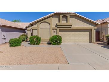 Charming single-story home with a beige exterior, well-manicured landscaping, and a two-car garage at 1946 E Kings Ave, Phoenix, AZ 85022
