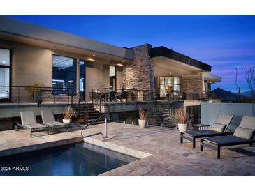 An outdoor view of a desert home with a private pool and multiple seating areas for entertaining and relaxation at 29218 N 107Th Way, Scottsdale, AZ 85262