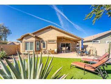 Inviting backyard featuring artificial grass, patio furniture, and a well-maintained landscape, ideal for outdoor relaxation at 31013 N Claridge Cir, San Tan Valley, AZ 85143