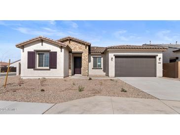 Beautiful single-story home with a stone facade and a two-car garage at 37650 W Nina St, Maricopa, AZ 85138