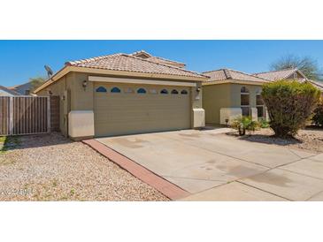 Charming single-story home with a beige exterior, tile roof, and well-maintained landscaping at 3805 S 73Rd Dr, Phoenix, AZ 85043
