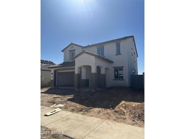 A two-story home boasting modern architecture, a covered entrance, a two car garage, and neutral color scheme at 43372 N Wollemi St, Queen Creek, AZ 85140