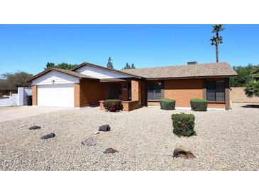 Charming red brick single-story home with desert landscaping and an attached garage at 4902 E Charter Oak Rd, Scottsdale, AZ 85254