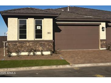 Charming exterior showcasing stone accents, a brown garage door, and a well-manicured lawn at 5633 N 205Th Ln, Buckeye, AZ 85396