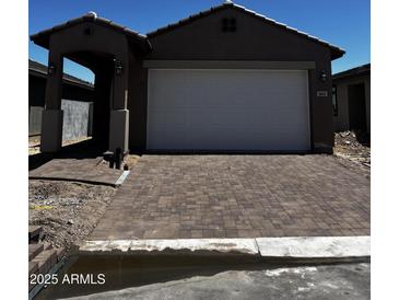 Charming home featuring a paved driveway, two-car garage, and covered portico at 5641 N 205Th Ln, Buckeye, AZ 85396