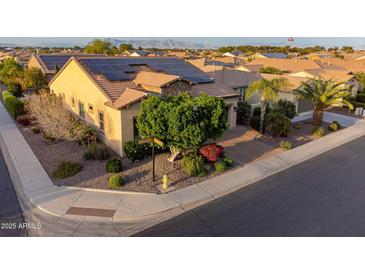 Inviting single-story home featuring mature landscaping, solar panels, and a charming brick-paved driveway at 37148 N Stoneware Dr, Queen Creek, AZ 85140