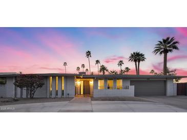 Charming single-story home featuring desert landscaping, a gray brick facade, and a private gated entrance at 4228 N 87Th St, Scottsdale, AZ 85251