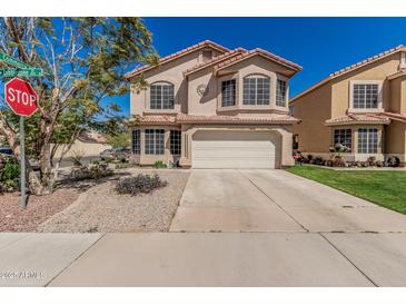 Charming two-story home with a tile roof, lush lawn, and an attached two-car garage at 439 N Cobblestone St, Gilbert, AZ 85234