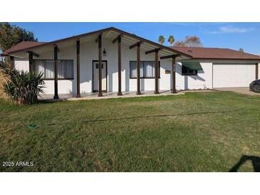 Charming single-story home featuring a well-manicured lawn and inviting facade with a two-car garage at 4728 N 61St Ave, Phoenix, AZ 85033