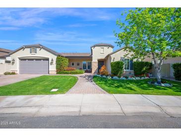 Charming single-story home with manicured lawn, beautiful landscaping, and a brick walkway leading to the entrance at 722 W Claremont St, Phoenix, AZ 85013