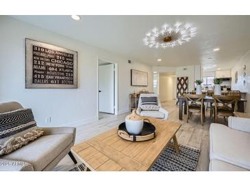 Inviting living room with modern decor, light wood floors and a stylish light fixture at 7430 E Chaparral Rd # A243, Scottsdale, AZ 85250