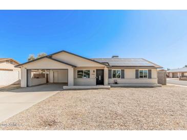 Charming single-story home featuring a carport, solar panels, and low-maintenance landscaping at 9903 N 87Th Dr, Peoria, AZ 85345