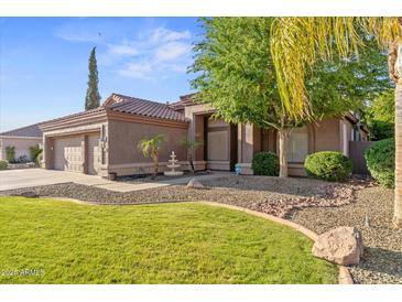 Charming single-story home showcasing desert landscaping, a three-car garage, and a welcoming front entry at 2894 E Melody Ln, Gilbert, AZ 85234