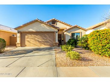 Inviting single-Gathering home with a well-manicured front yard and a two-car garage at 45564 W Sheridan Rd, Maricopa, AZ 85139
