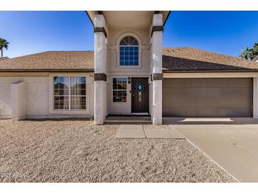 Charming home exterior with pillars, neutral color scheme, and a well-maintained front yard at 4940 E Grandview St, Mesa, AZ 85205