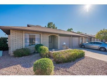 Charming single-story brick home with a well-manicured lawn, attached garage, and a sunny blue sky at 520 S Greenfield Rd # 22, Mesa, AZ 85206