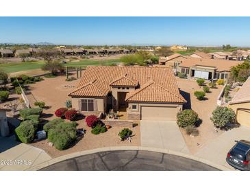 Attractive single-story home features well-maintained landscaping, a tile roof, and a two-car garage in a golf community at 5812 S Staghorn Cholla Ct, Gold Canyon, AZ 85118