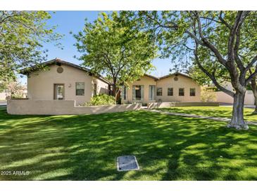 Well-maintained home exterior with a lush green lawn and mature trees at 8336 S Homestead Ln, Tempe, AZ 85284