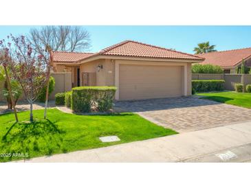 Charming single-story home featuring a terra cotta roof and a two-car garage at 8877 E Riviera Dr, Scottsdale, AZ 85260