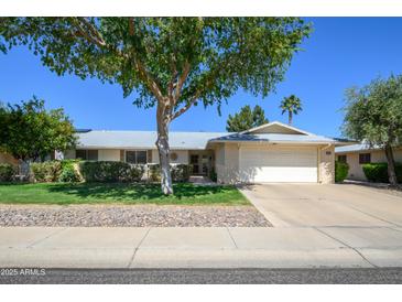 Charming single-story home with a well-maintained lawn and mature landscaping, creating inviting curb appeal at 12634 W Seneca Dr, Sun City West, AZ 85375