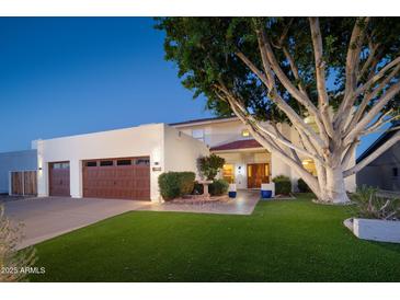 Inviting single-Gathering home featuring a lush lawn, mature tree, private entrance and a two-car garage at 15021 N 19Th Way, Phoenix, AZ 85022