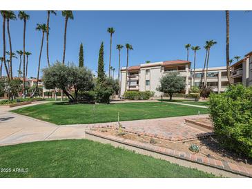 Beautifully landscaped community with lush green spaces and mature trees at 17404 N 99Th Ave # 214, Sun City, AZ 85373