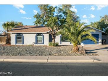 Charming single-story home featuring rock landscaping, mature trees, and a two-car garage at 2253 S Emerson --, Mesa, AZ 85210