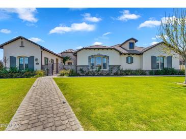Stunning single Gathering home featuring beautiful landscaping, a paver walkway, and a private gated entrance at 4037 E Minton Cir, Mesa, AZ 85215