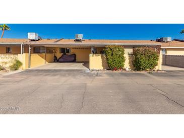 Charming home featuring a covered carport and well-maintained landscaping with decorative shrubs and colorful flower accents at 711 E Laurel Dr # 17, Casa Grande, AZ 85122