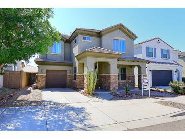 Beautiful two-story home featuring a stone-accented facade, desert landscaping, and a welcoming covered porch at 7712 S 37Th Way, Phoenix, AZ 85042