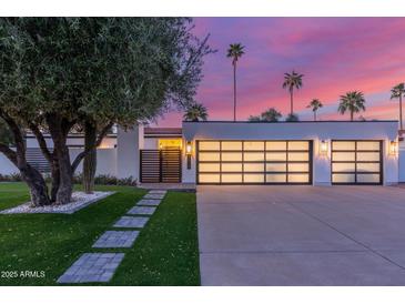 Modern home featuring a well-manicured lawn, sleek garage doors, and a charming walkway at 8618 E Via De Encanto --, Scottsdale, AZ 85258