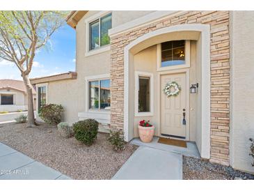 Inviting front entrance with stone accents, decorative wreath, and beautiful desert landscaping at 1024 E Frye Rd # 1093, Phoenix, AZ 85048