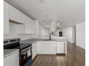 Bright kitchen featuring white cabinetry, stainless steel appliances, and wood-look flooring at 11474 N 79Th Dr, Peoria, AZ 85345