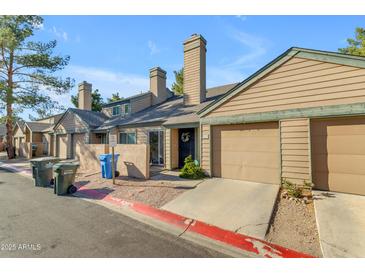 Charming townhouse featuring a private garage, well-maintained landscaping, and inviting front entrance at 14002 N 49Th Ave # 1029, Glendale, AZ 85306