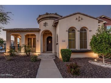 Charming home exterior featuring a unique turret entrance, arched windows, and well-maintained landscaping at 15480 W Corrine Dr, Surprise, AZ 85379